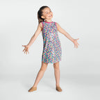 Young girl wearing a colorful patterned dress on a white background