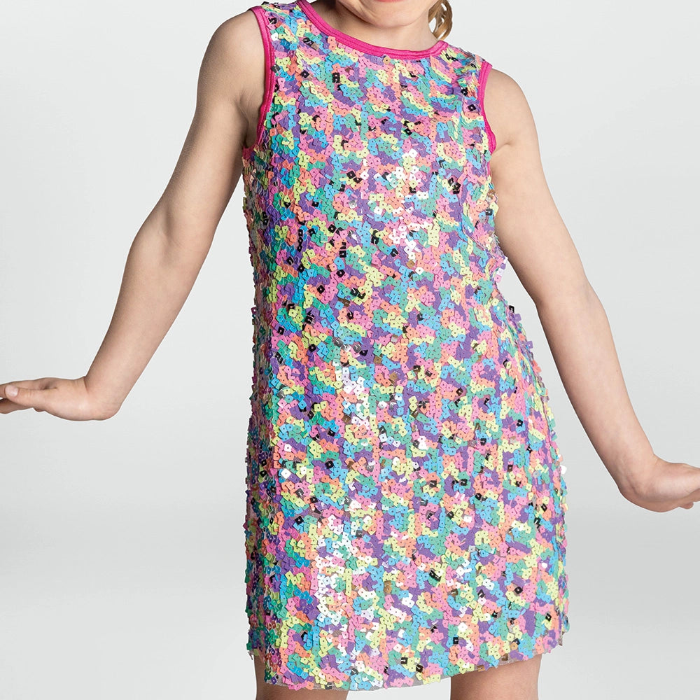 Child wearing a colorful floral dress on a plain background