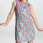 Child wearing a colorful floral dress on a plain background