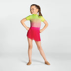 Young girl in a colorful outfit with a gradient top and pink fringed skirt on a white background