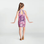 Girl wearing a pink and purple tie-dye dress on a white background