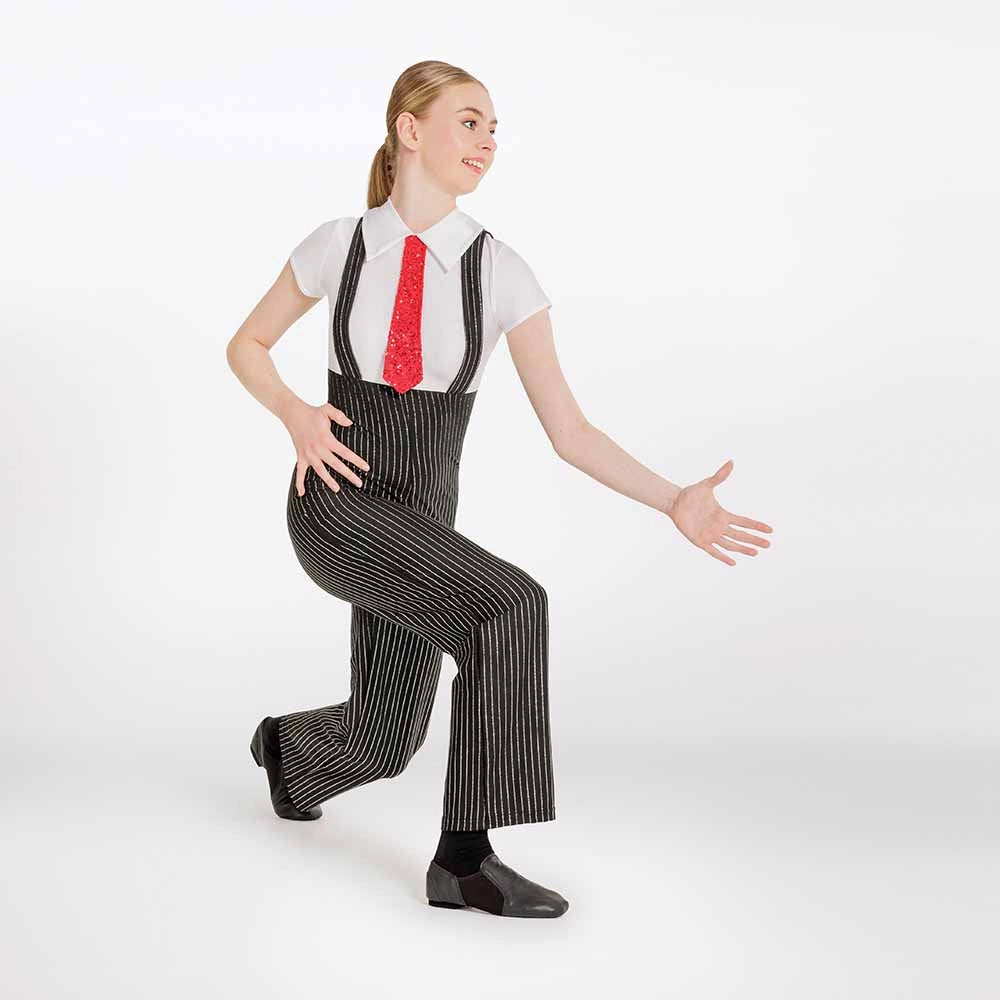 A woman modeling a black and white pinstripe costume jumpsuit with a white shirt, red tie, and black shoes against a plain white studio background.