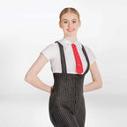 A woman modeling a black and white pinstriped jumpsuit with shoulder straps, styled over a white short-sleeve collared shirt and a red patterned necktie, against a plain white studio background.