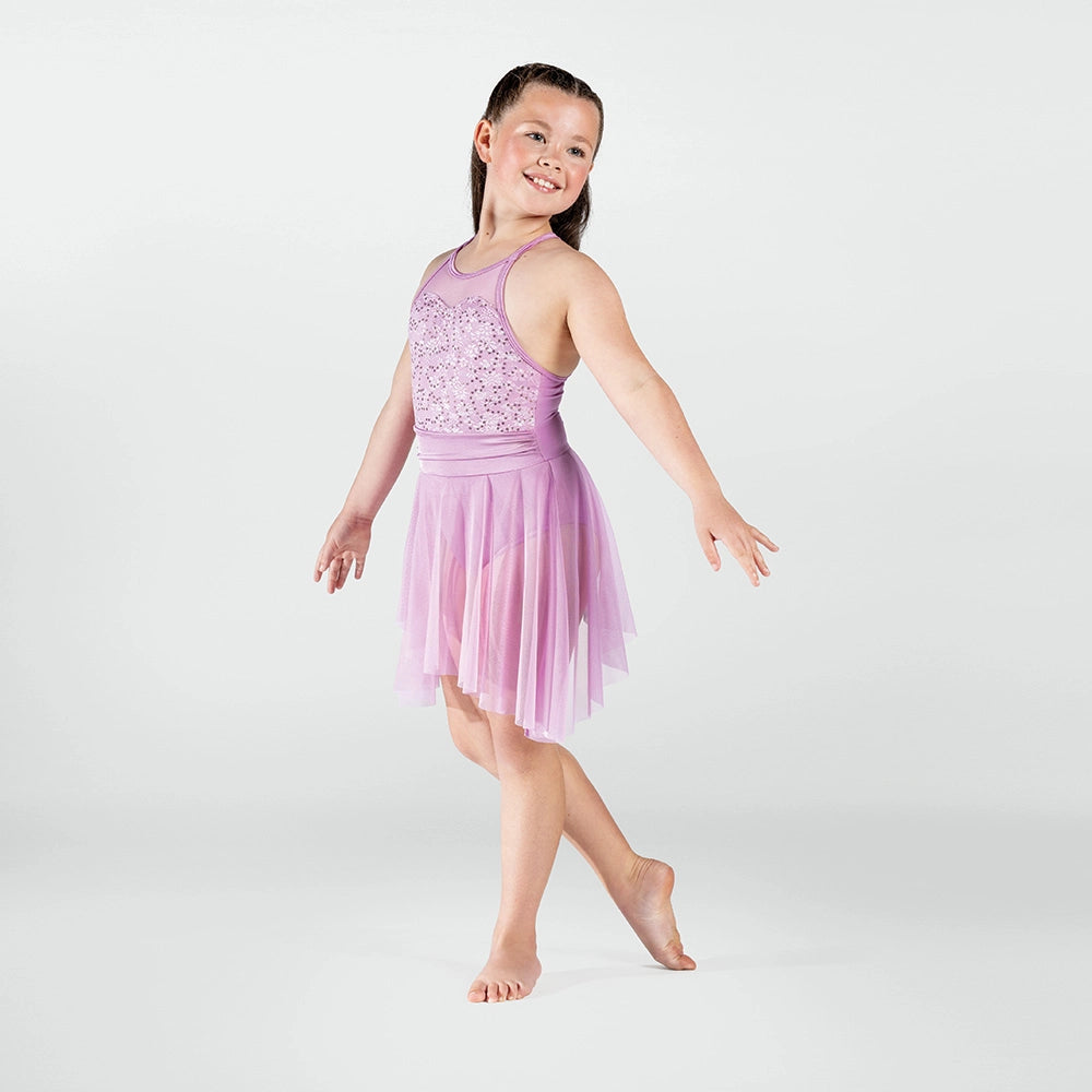Young girl in a pink dance outfit posing on a white background