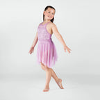 Young girl in a pink dance outfit posing on a white background