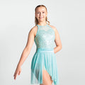 Person wearing a light blue figure skating dress with sequined top on a white background