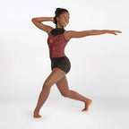 Dancer in a red and black leotard posing on a white background