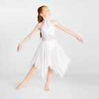 Young girl in a white dress posing against a plain background