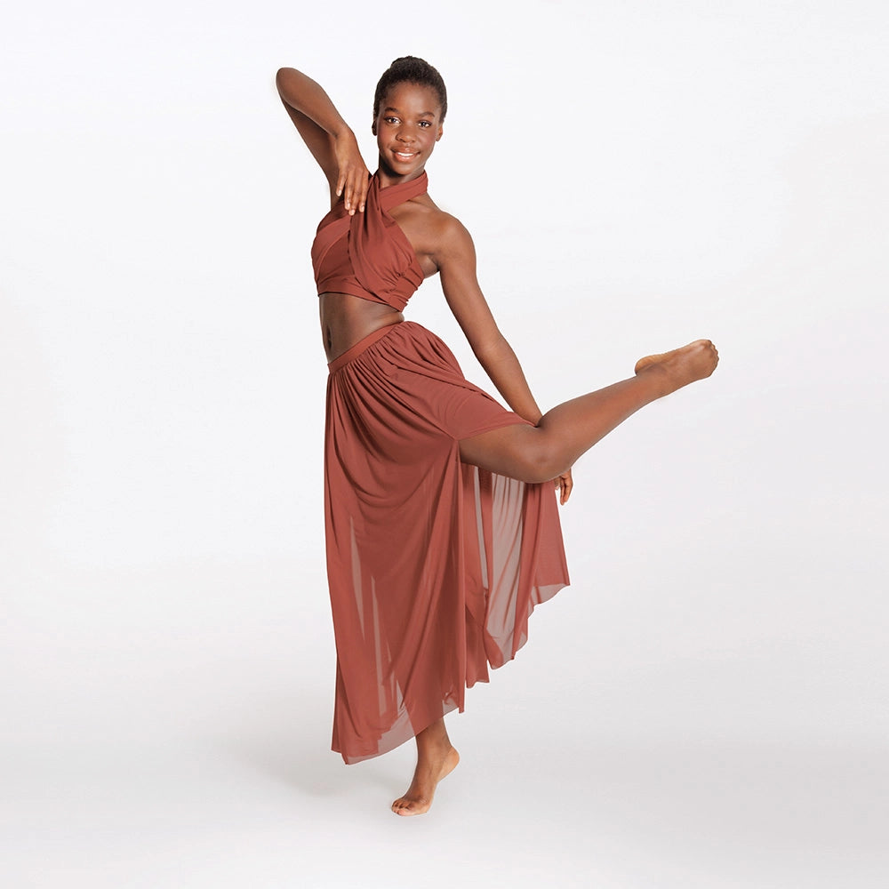 Dancer in a flowing rust-colored dress posing on a white background