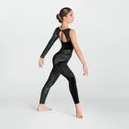 A woman modeling a black dance leotard with sheer mesh panels and a subtle glittery texture, shown from the back and side against a light gray studio background.