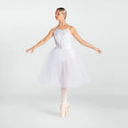 A woman in a white ballet tutu dress with a lace bodice and tulle skirt, posed en pointe on a light gray studio background.