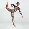 A female dancer in a leopard-print leotard with sheer black long sleeves poses dynamically against a light gray studio background.