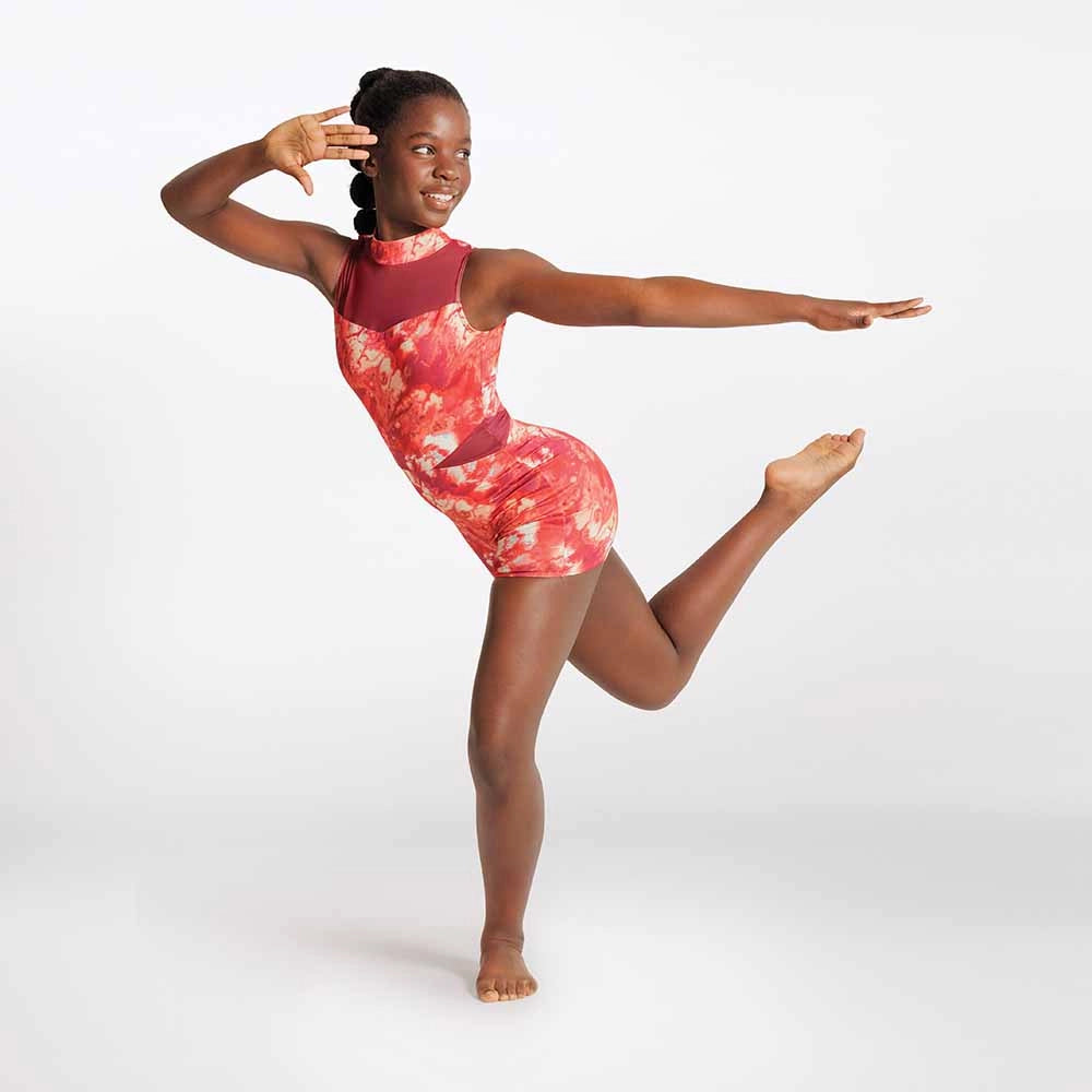 Dancer in a red and white patterned leotard posing on a white background
