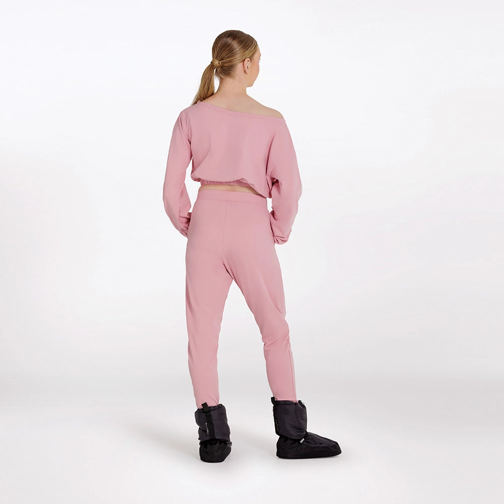 Person wearing a pink outfit with black boots on a white background