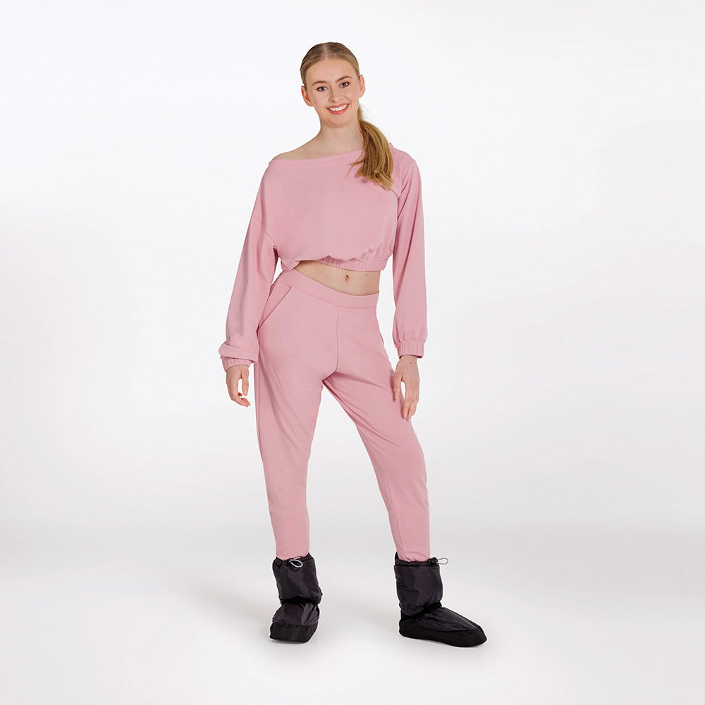 Woman wearing a pink outfit with black boots on a white background