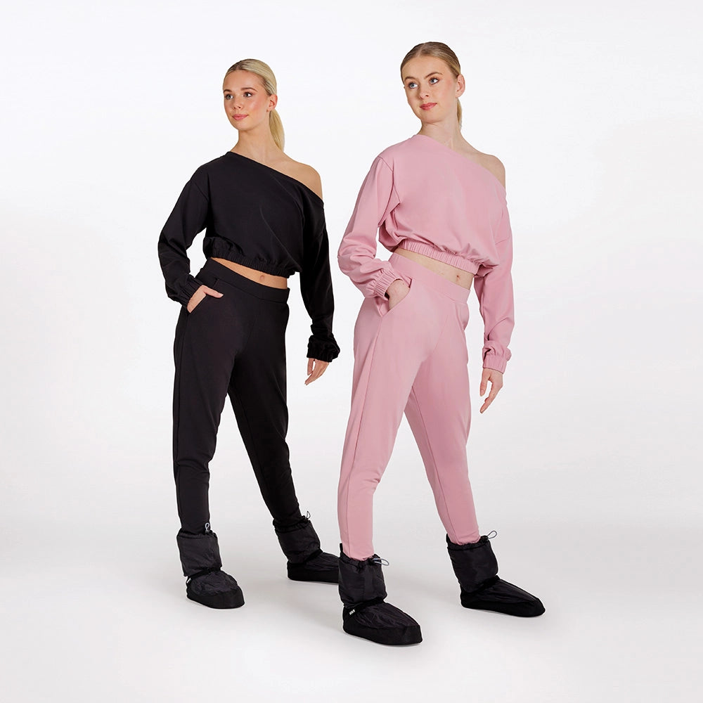 Two women wearing black and pink outfits with matching shoes on a white background
