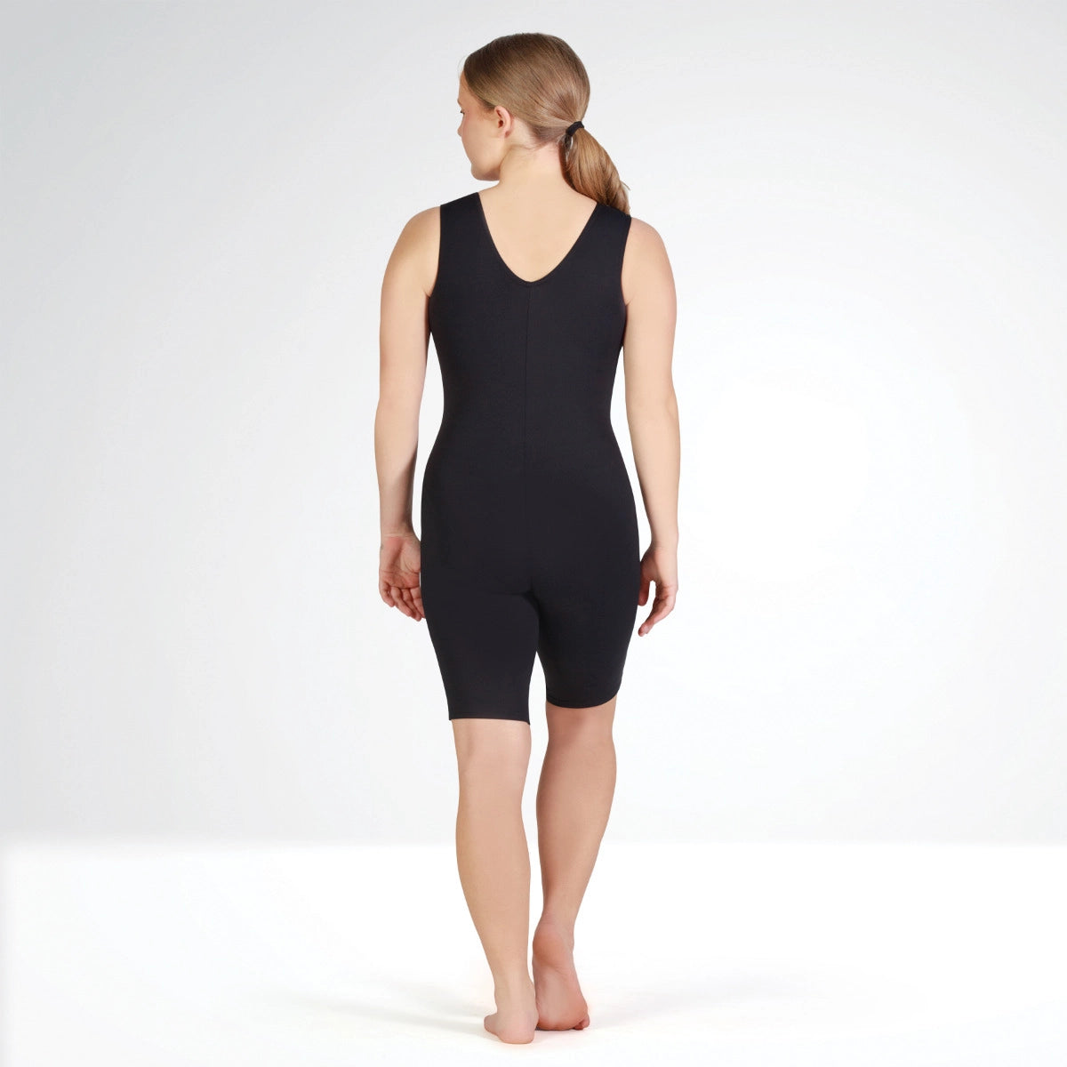 Person wearing a black bodysuit on a white background