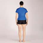 Person wearing a blue top and black shorts on a plain background