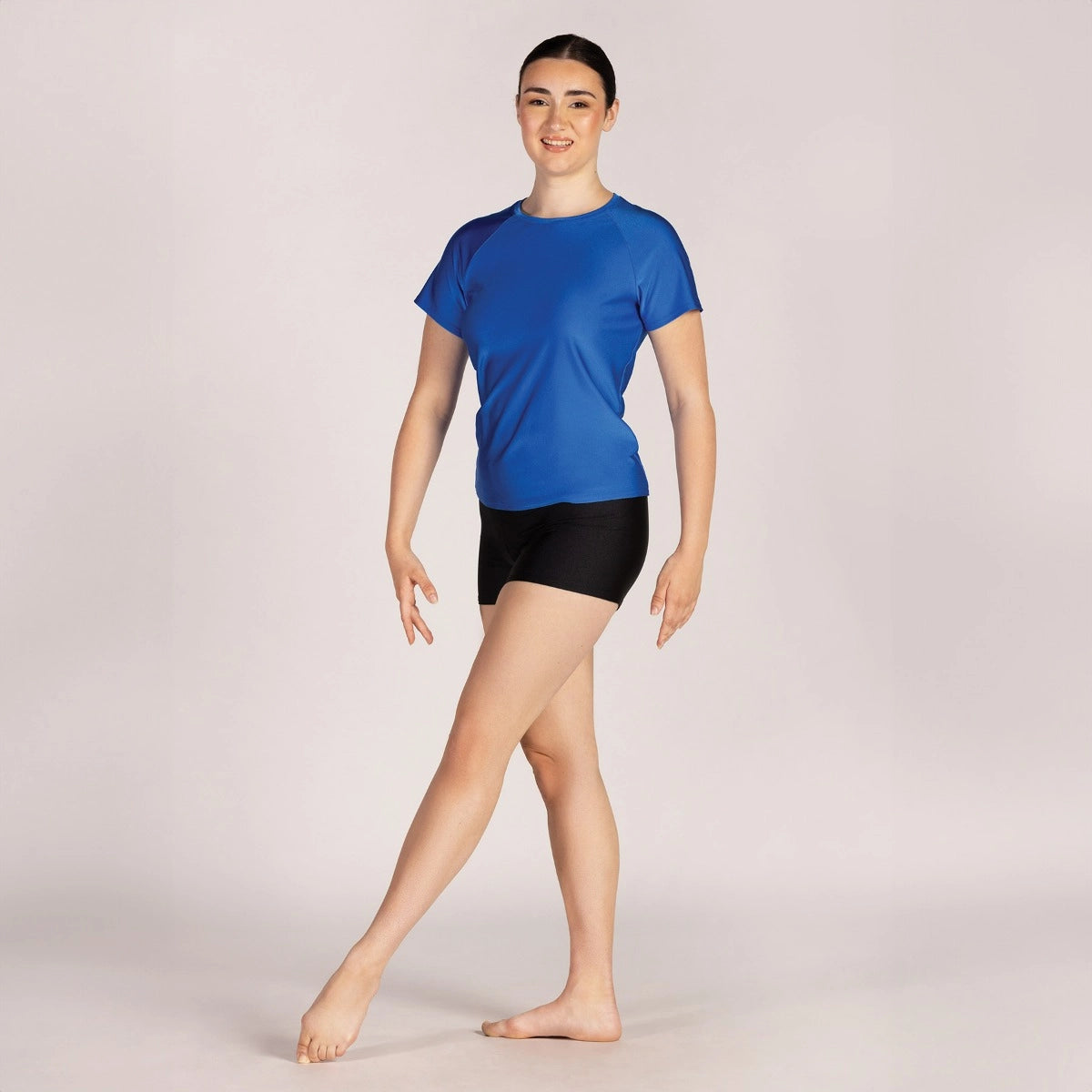 Person wearing a blue athletic shirt and black shorts on a plain background