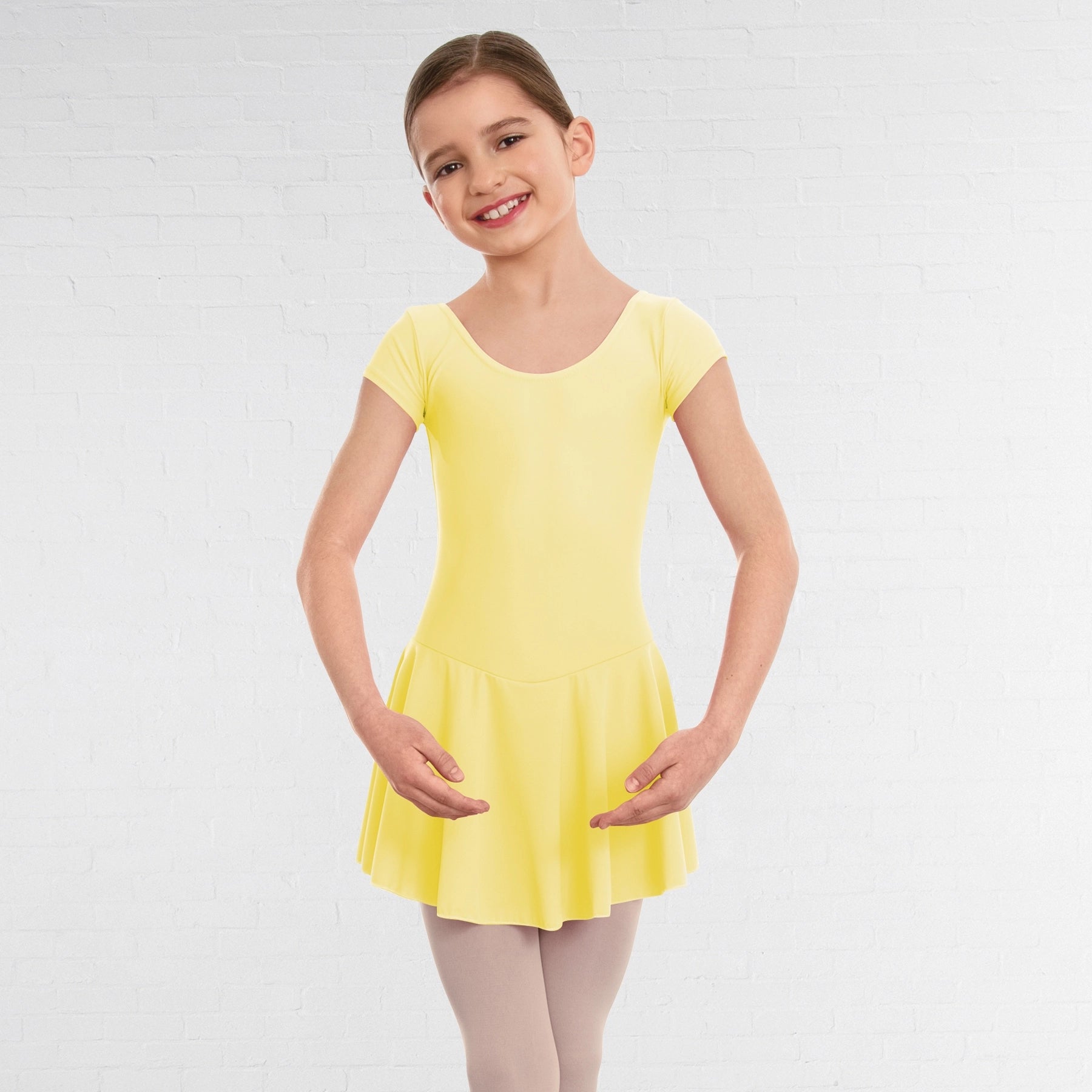 Young girl wearing a yellow dress against a white background
