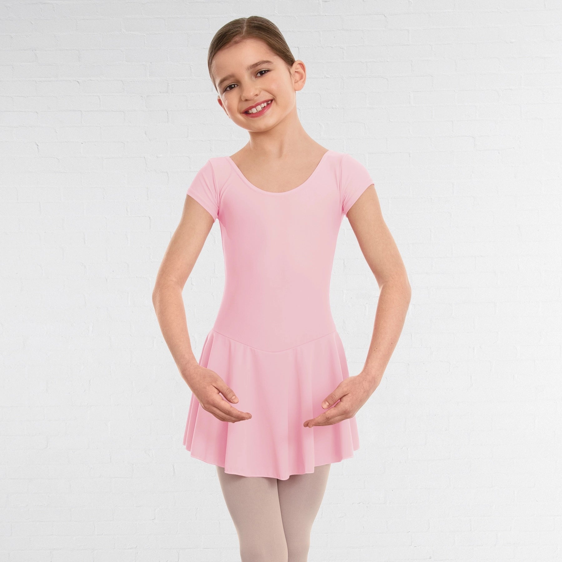 Young girl wearing a pink dress against a white background