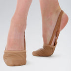 Brown ballet shoes worn by a person on a white background