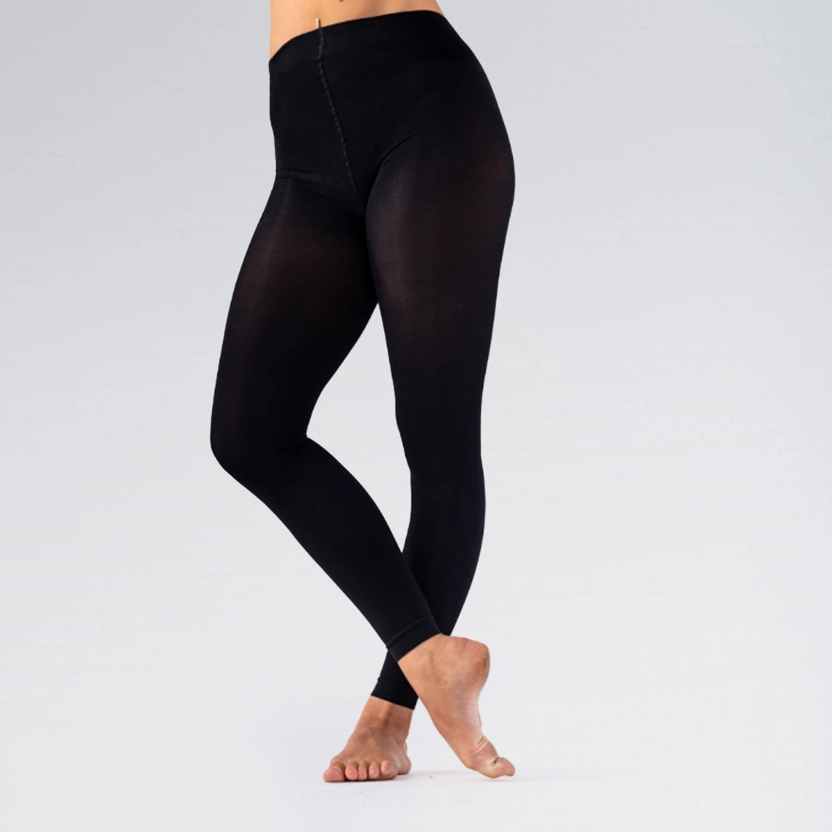 Black leggings worn by a person on a light gray background