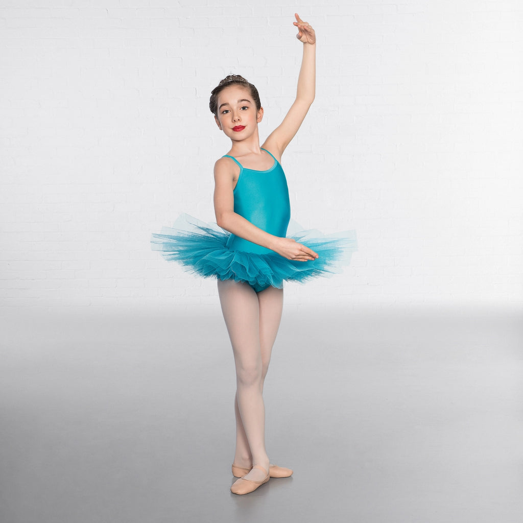Young dancer in a turquoise ballet outfit posing against a white background