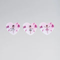 Three heart-shaped stickers with ballerina designs on a light gray background