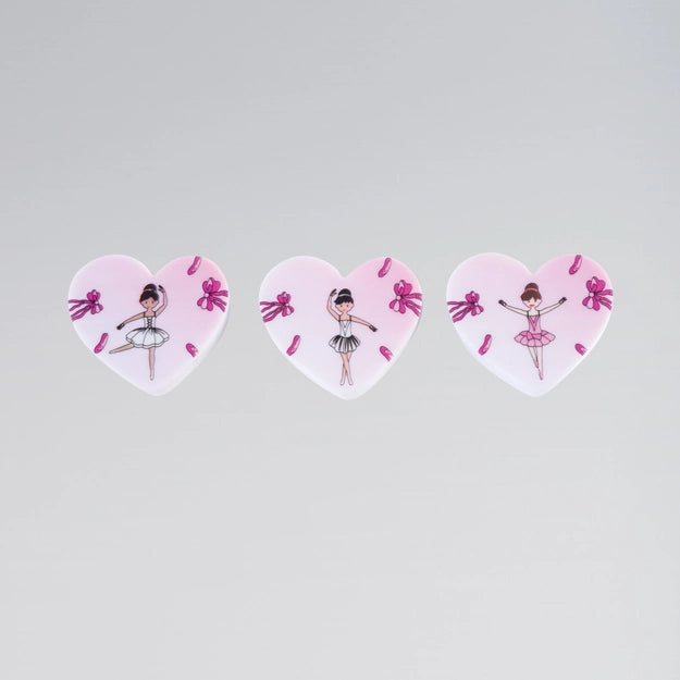 Three heart-shaped stickers with ballerina designs on a light gray background