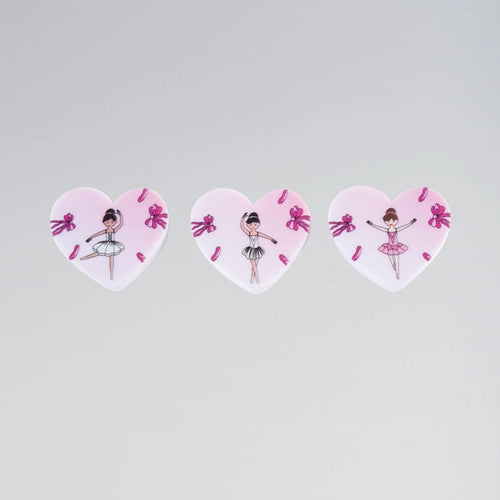 Three heart-shaped stickers with ballerina designs on a light gray background