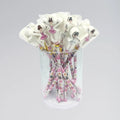 Bouquet of pink and white straws with ballerina design in a clear glass container on a gray background